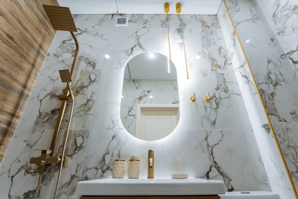 the bathroom features essential elements including a stylish sink, a wellplaced mirror, and an overhead shower head, creating a functional yet aesthetically pleasing space